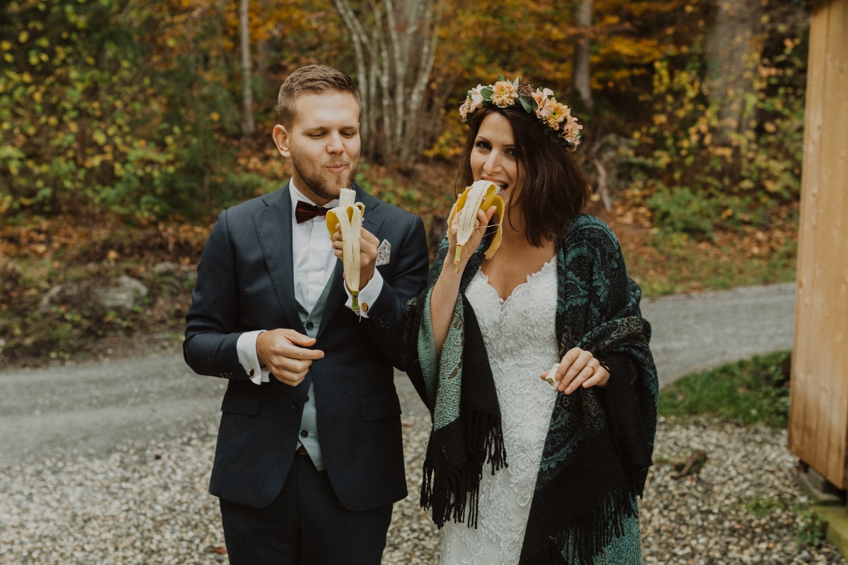 Paar isst Banane in Hochzeitskleidern
