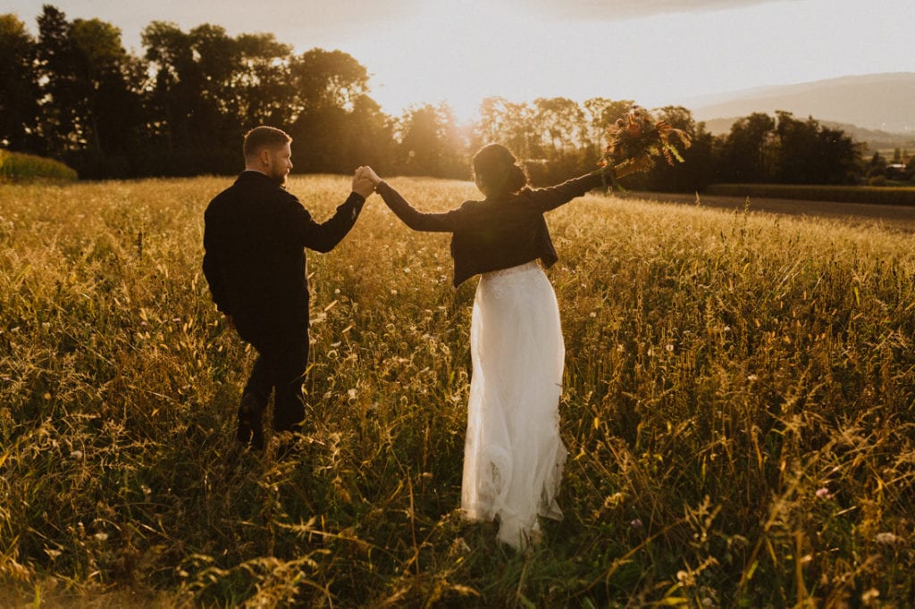 Boho Hochzeit Biel Hochzeitspaar in einem Feld beim Sonnenuntergang