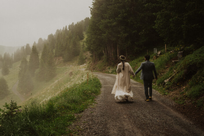 Alpenhochzeit in Arosa Brautpaar am wandern im Nebel