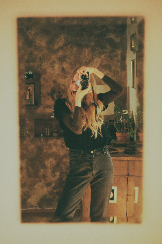 Girl takes an analogue picture in the mirror