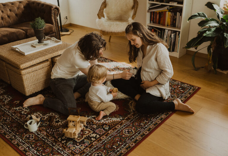 Familie spielt zusammen auf dem Boden im Wohnzimmer