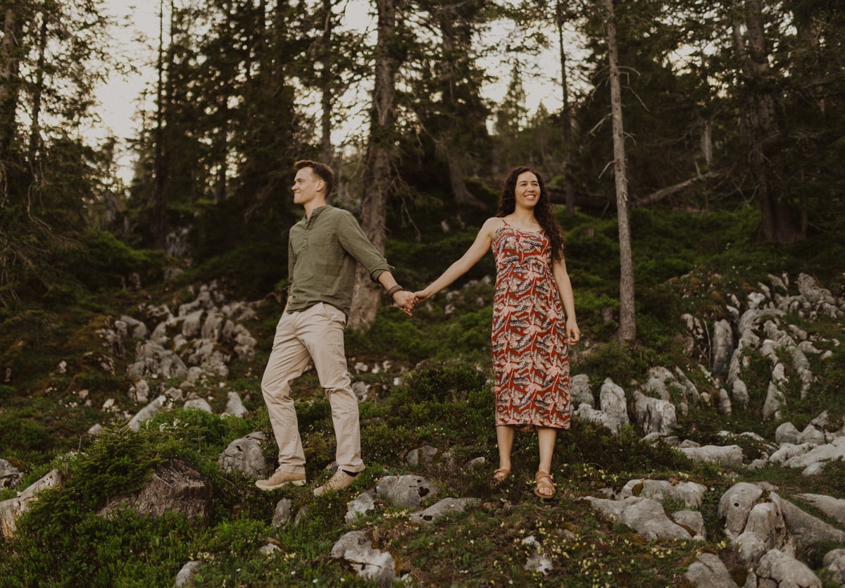 Paar steht auf Felsen im Wald im Sörenberg