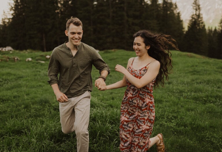 Paar rennt auf einer Wiese im Sörenberg