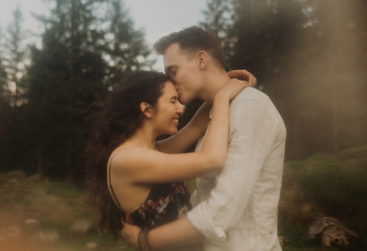 Mann küsst Frau auf die Stirn