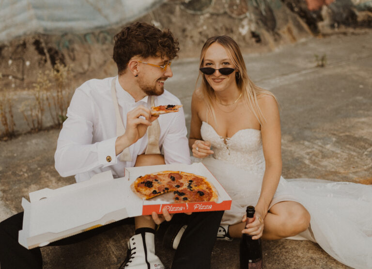 Braut und Bräutigam essen Pizza am Hochzeit