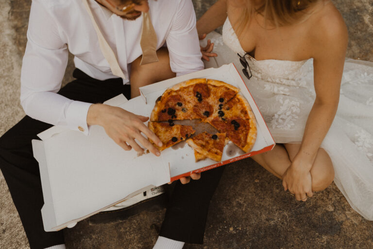 Brautpaar trinkt Champagner und isst Pizza