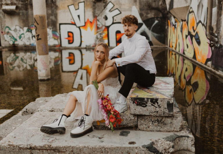 Braut und Bräutigam mit Graffitis im Hintergrund