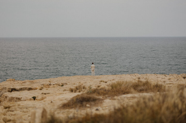 Bräutigam wartet am Meer in Kreta auf seine Braut.