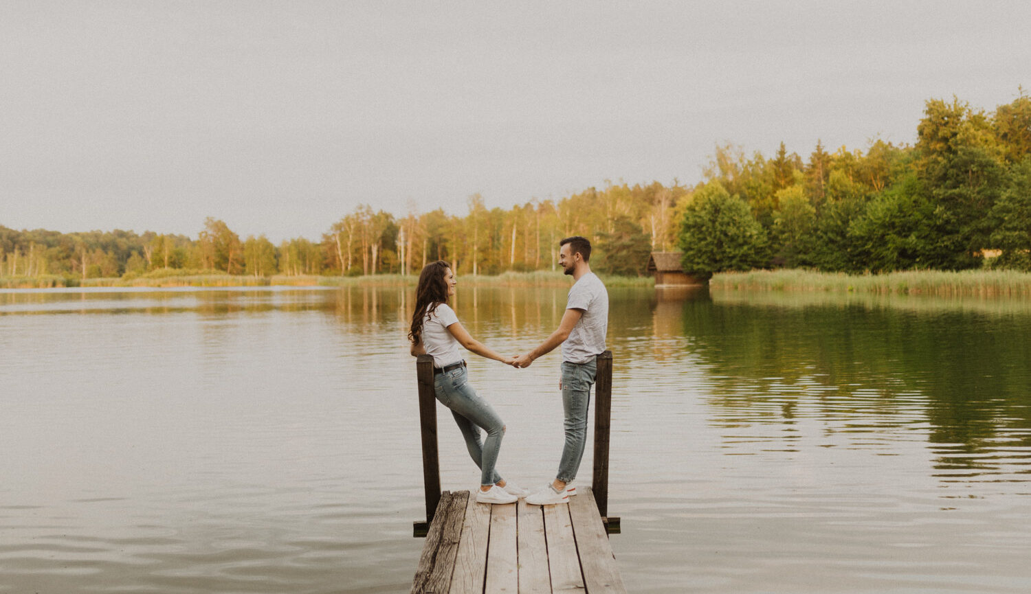 Paar steht auf einem Steg beim Husemersee und hält sich die Hände