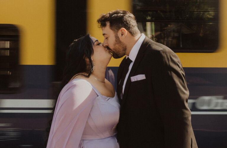 Wedding couple kisses in front of a swiss train.