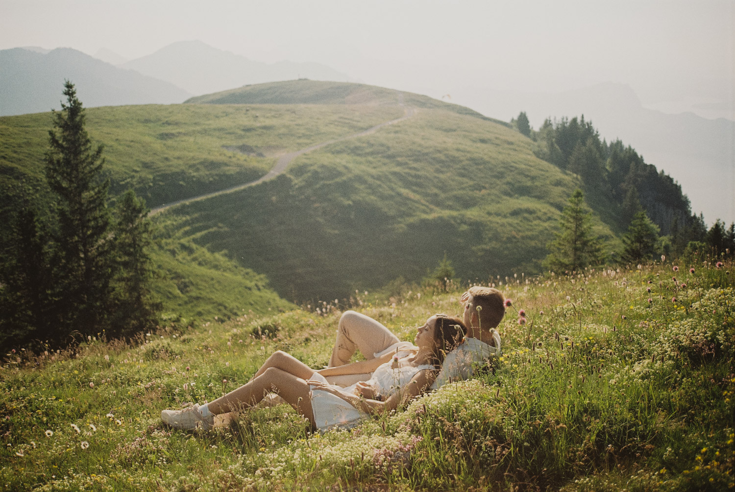 lucerne-proposal-photography laying in a meadow at the proposal photography session in lucerne with mountains in the background