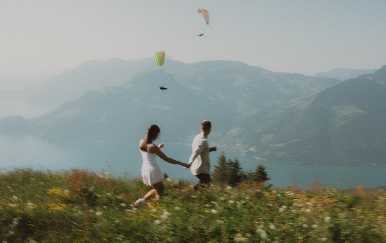 lucerne-proposal-photography walking in a meadow at the proposal photography session in lucerne with mountains in the background