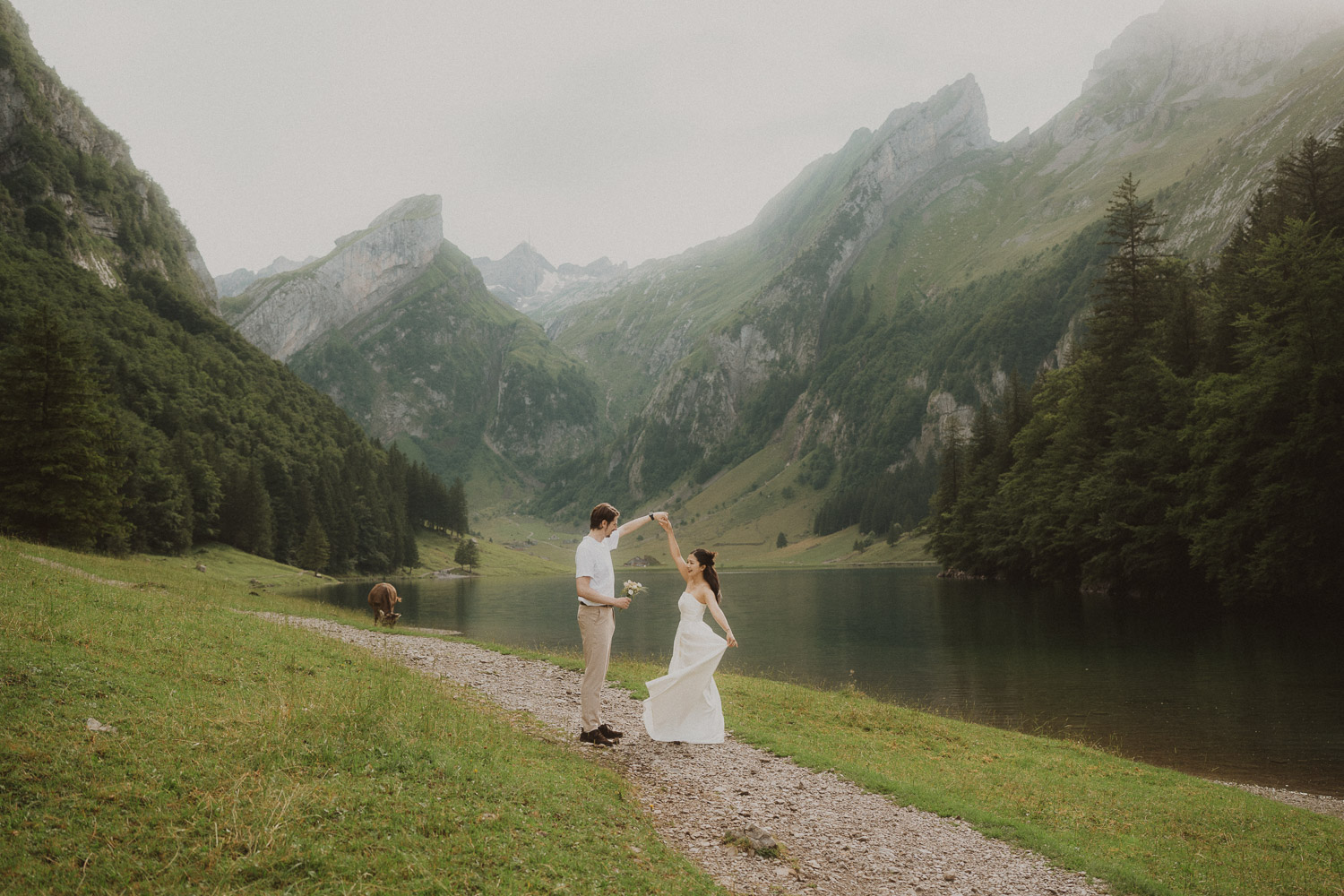 Couple eloping and dancing at Seealpsee in Appenzell, photographed by an elopement and proposal photographer.