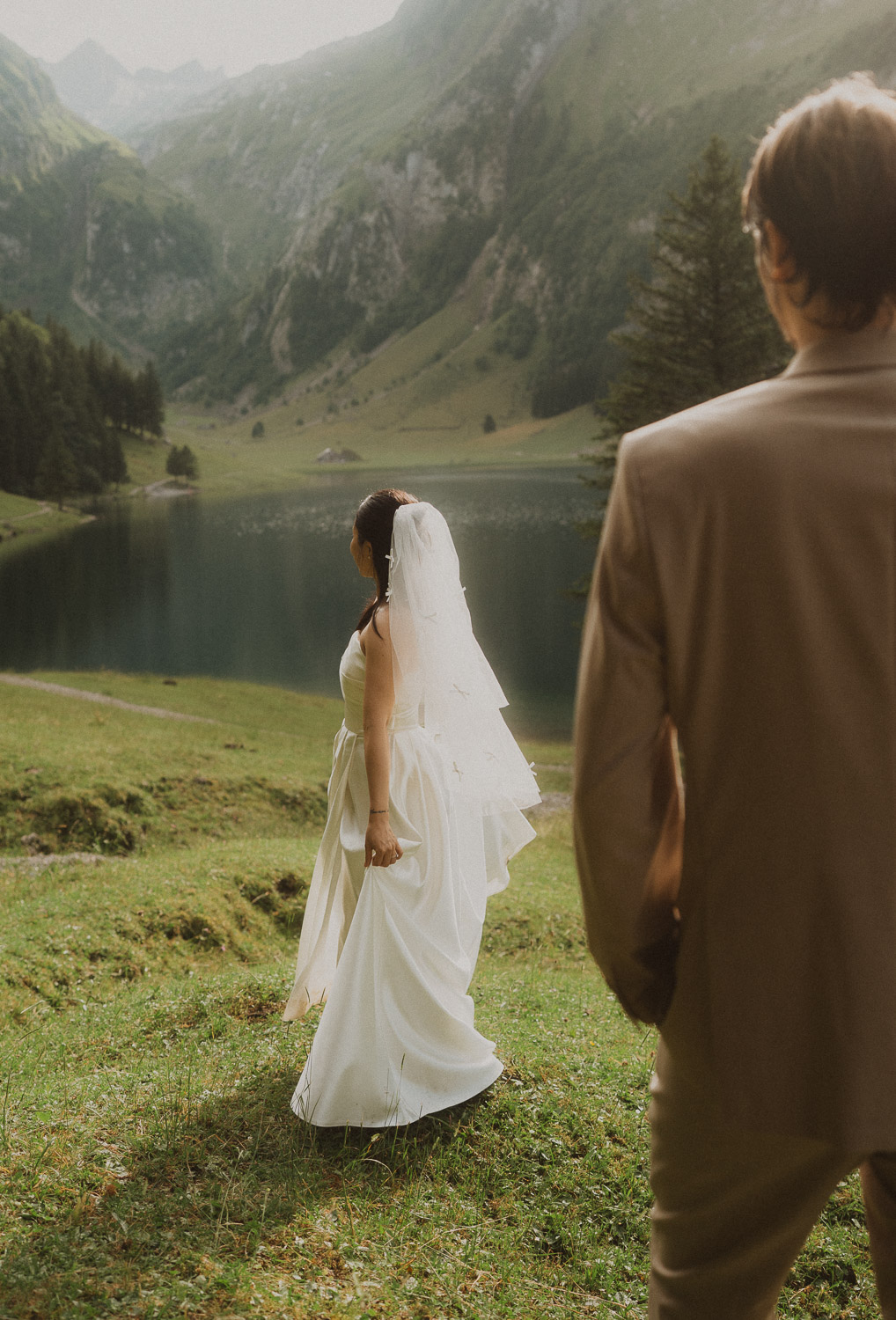 Couple eloping and dancing in front of Seealpsee in Appenzell, photographed by an elopement and proposal photographer.