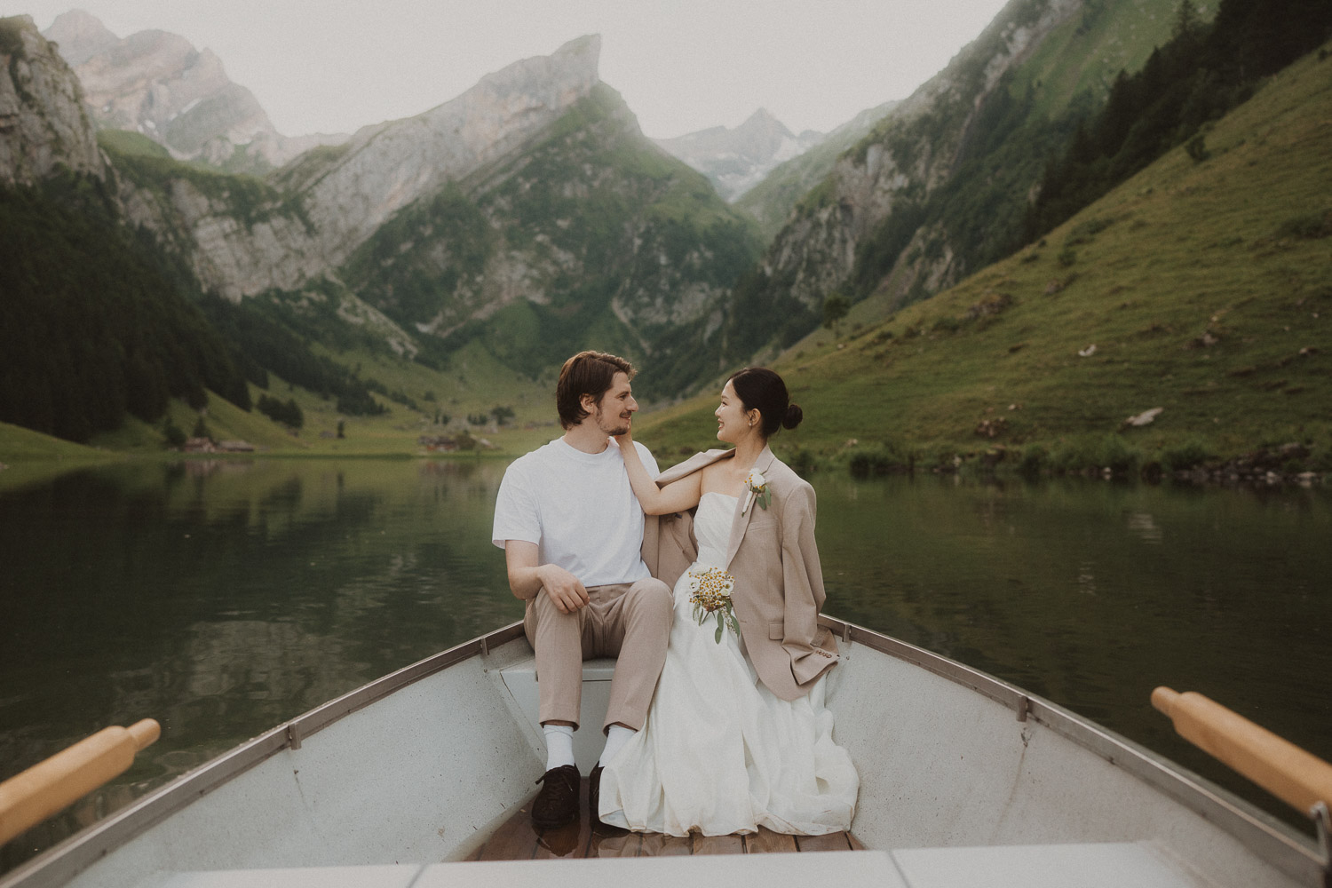 Couple eloping in a row boat at Seealpsee in Appenzell, photographed by an elopement and proposal photographer.