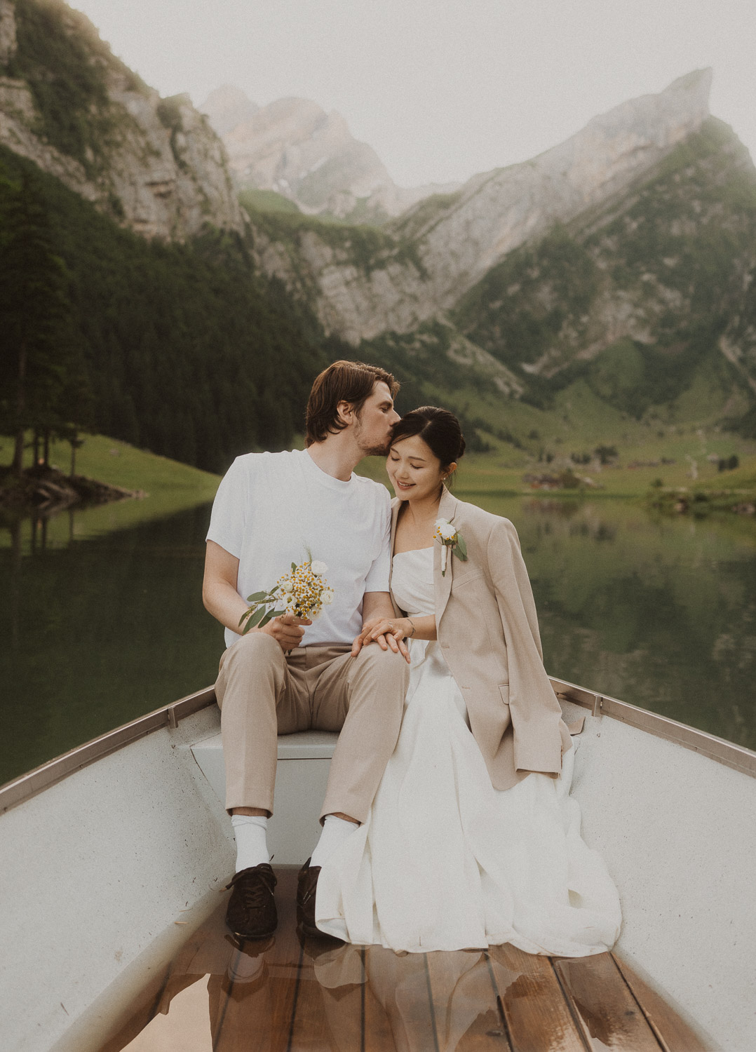 Couple eloping in a row boat at Seealpsee in Appenzell, photographed by an elopement and proposal photographer.