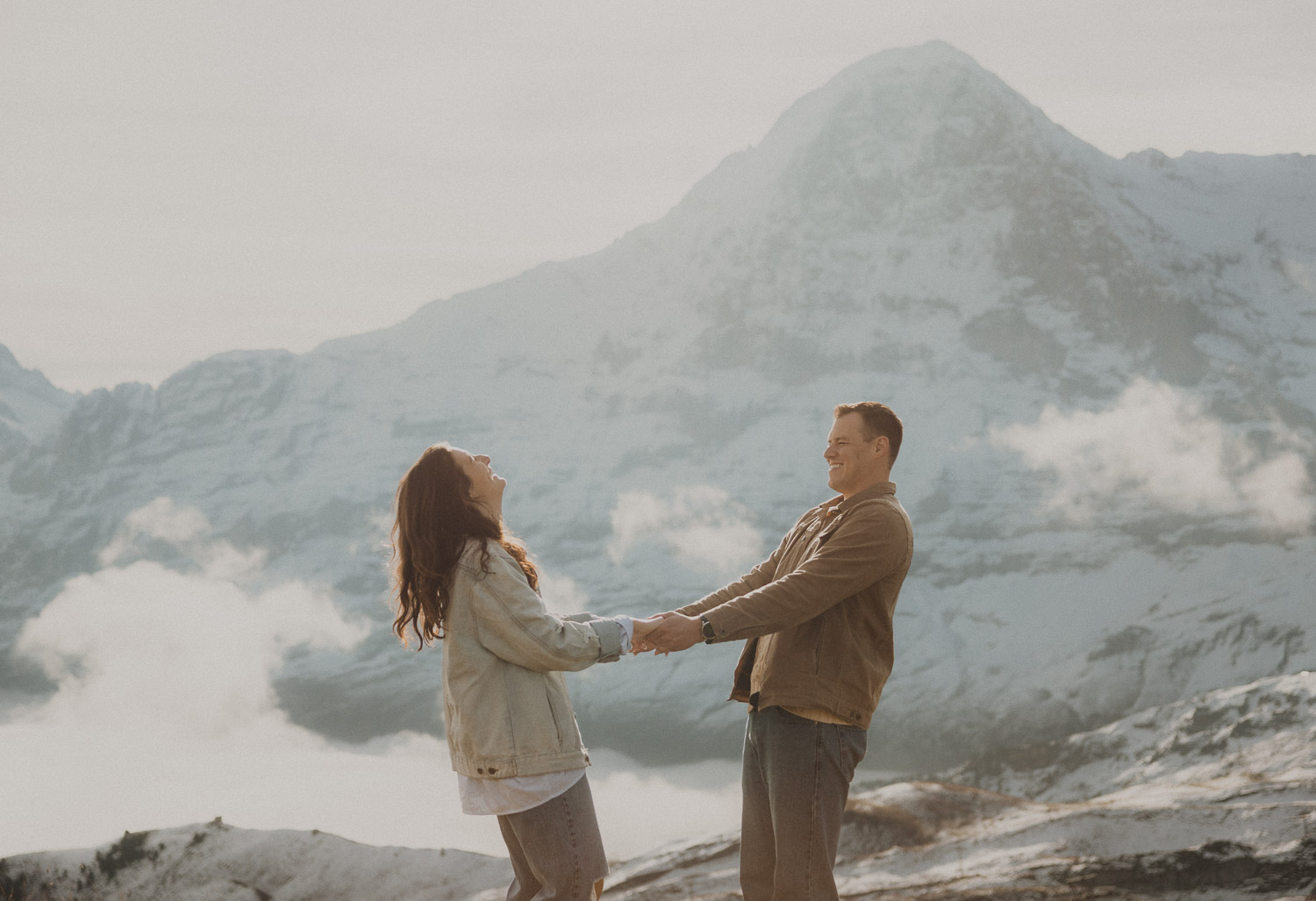 Couple at a surprise proposal photography session in the Jungfrauregion with alpine mountain scenery and natural outdoor setting in daylight.