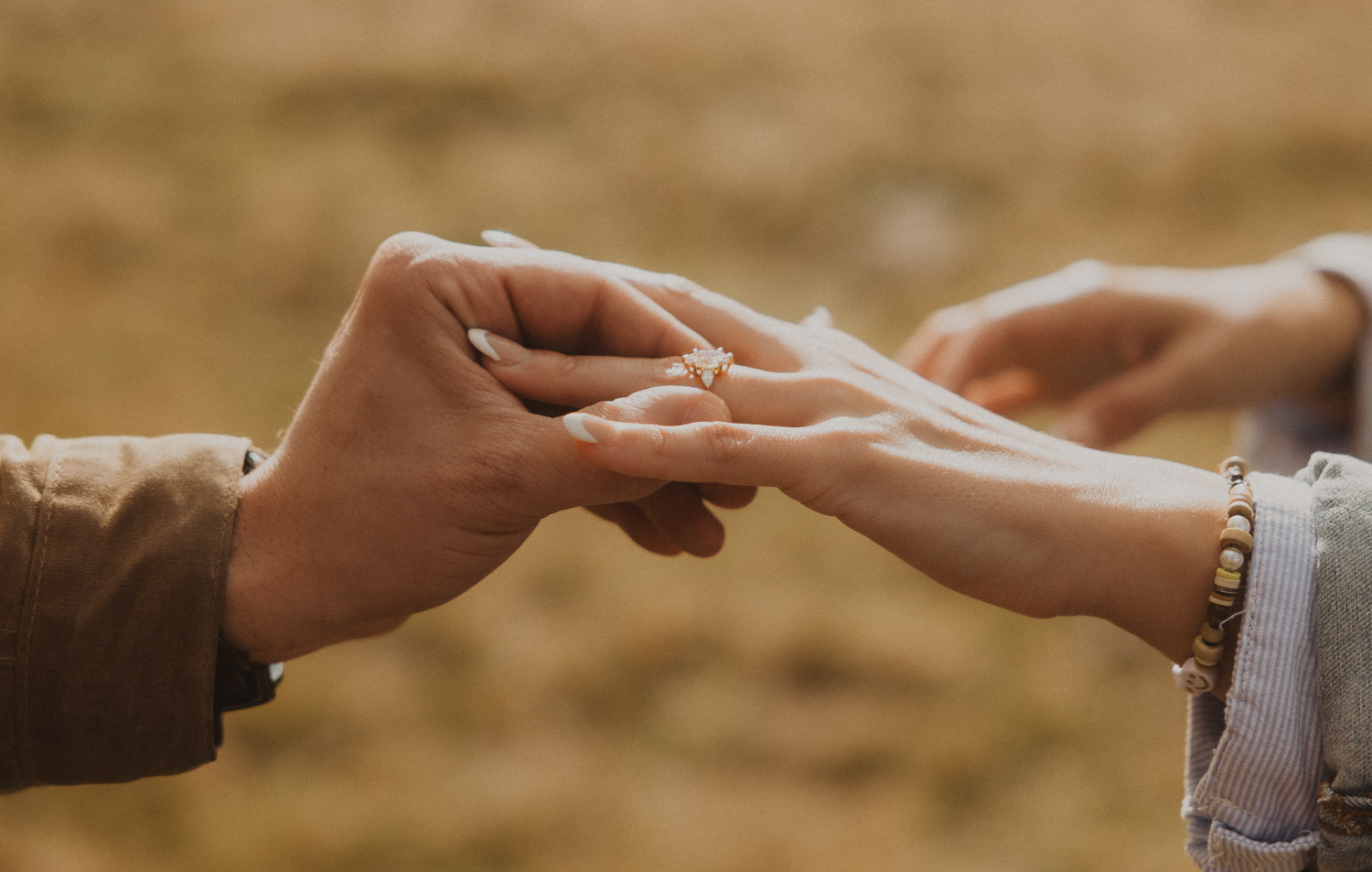 Man putting a ring on her hand at a surprise proposal photography session in the Jungfrauregion with alpine mountain scenery and natural outdoor setting in daylight.
