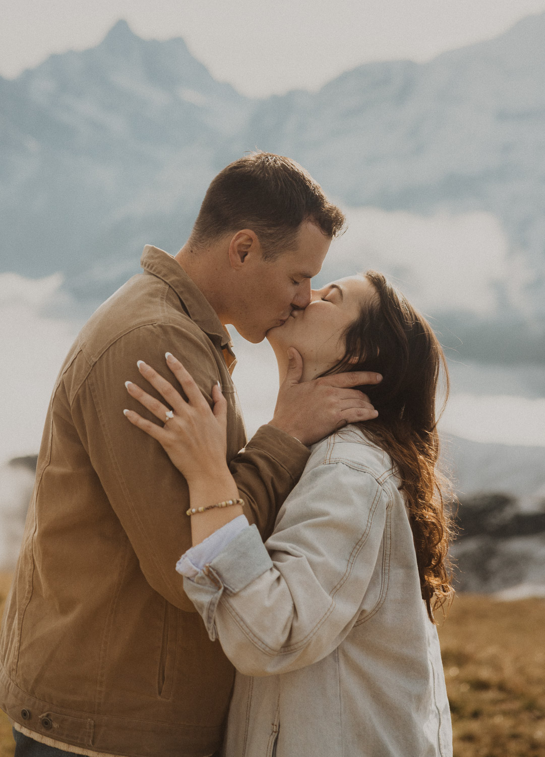 Couple kissing at a surprise proposal photography session in the Jungfrauregion with alpine mountain scenery and natural outdoor setting in daylight.