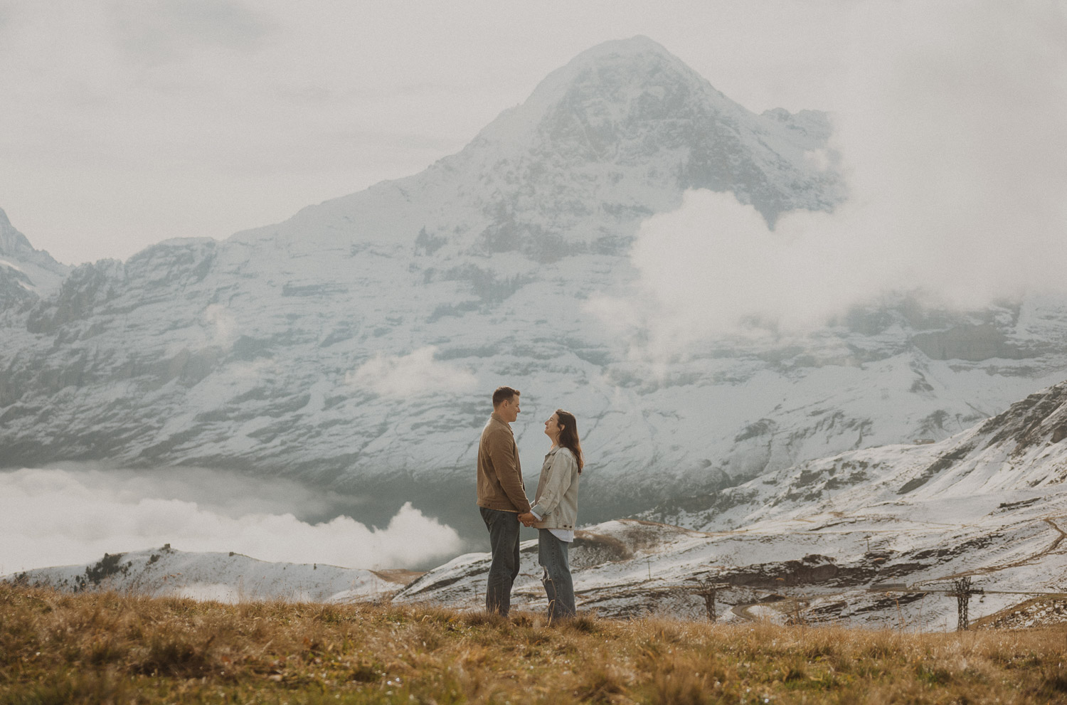 Couple at a surprise proposal photography session in the Jungfrauregion with alpine mountain scenery and natural outdoor setting in daylight.