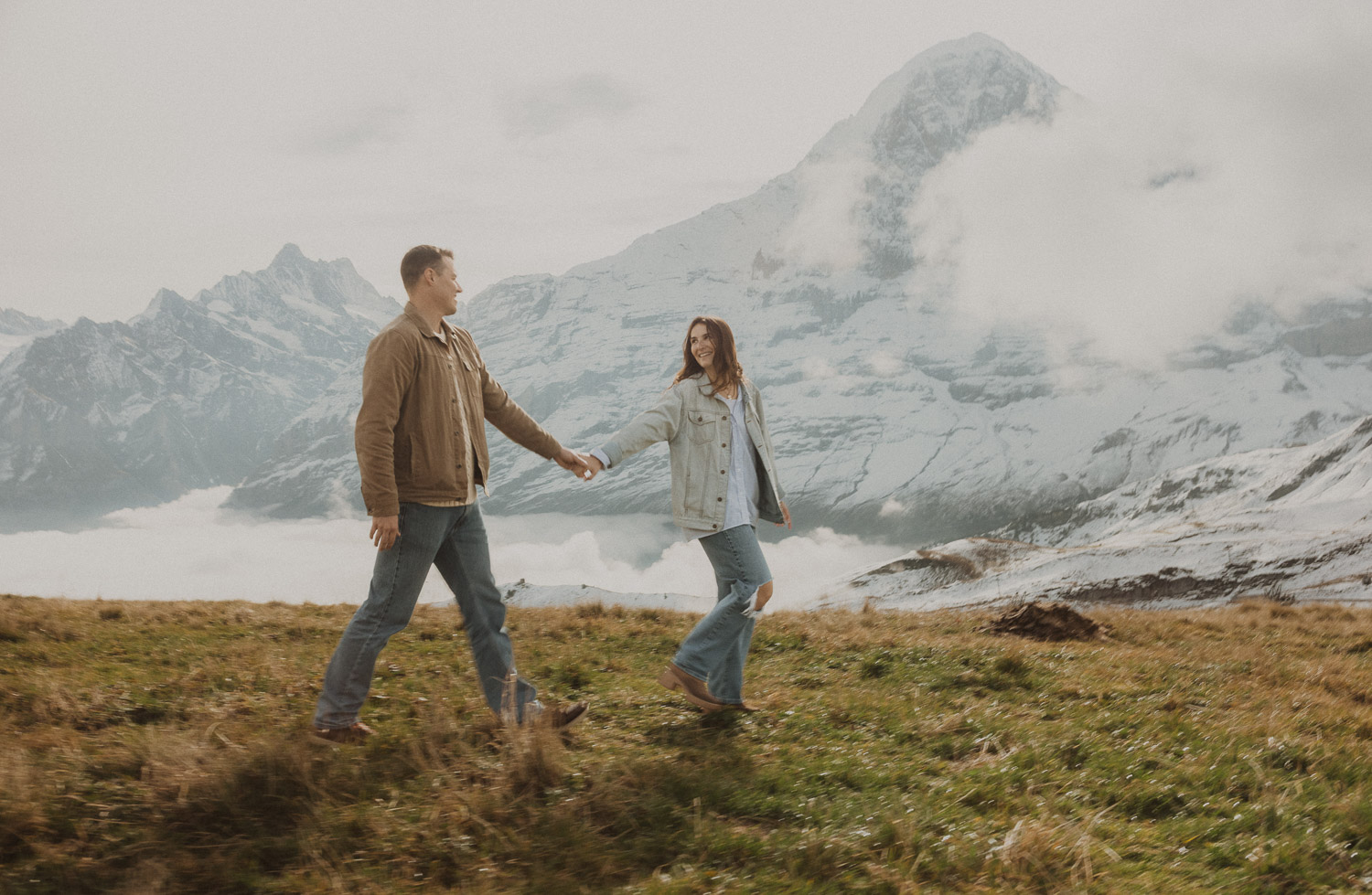 Couple walking at a surprise proposal photography session in the Jungfrauregion with alpine mountain scenery and natural outdoor setting in daylight.
