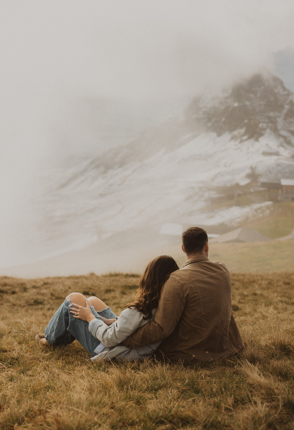 Couple enjoying the scenery at a surprise proposal photography session in the Jungfrauregion with alpine mountain scenery and natural outdoor setting in daylight.