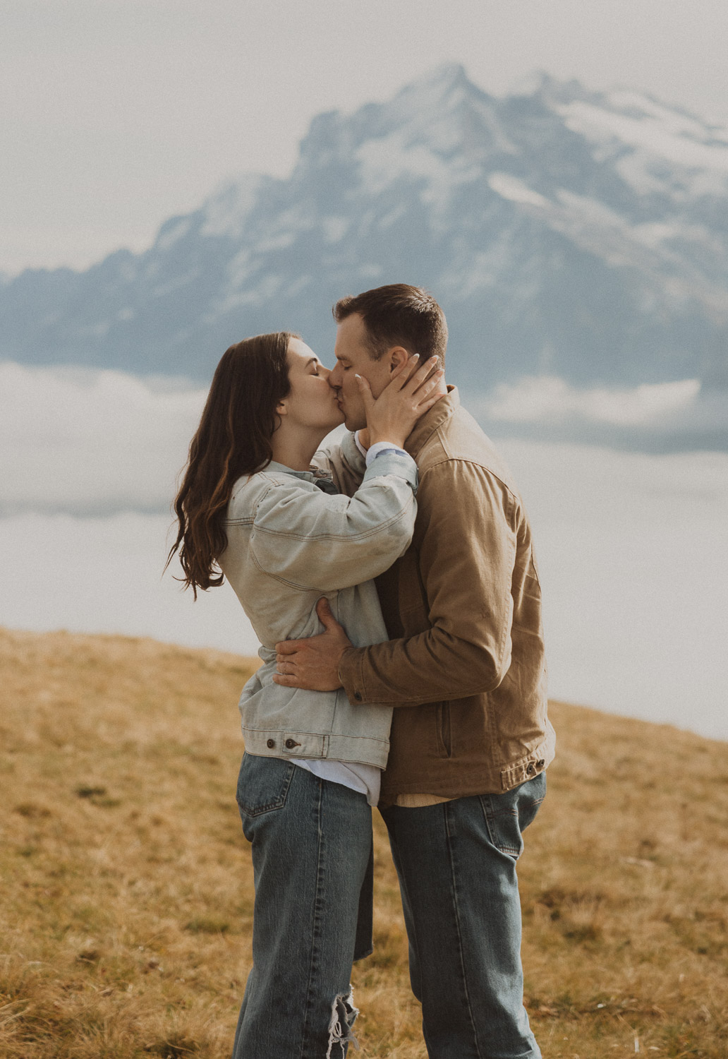 Couple kissing at a surprise proposal photography session in the Jungfrauregion with alpine mountain scenery and natural outdoor setting in daylight.