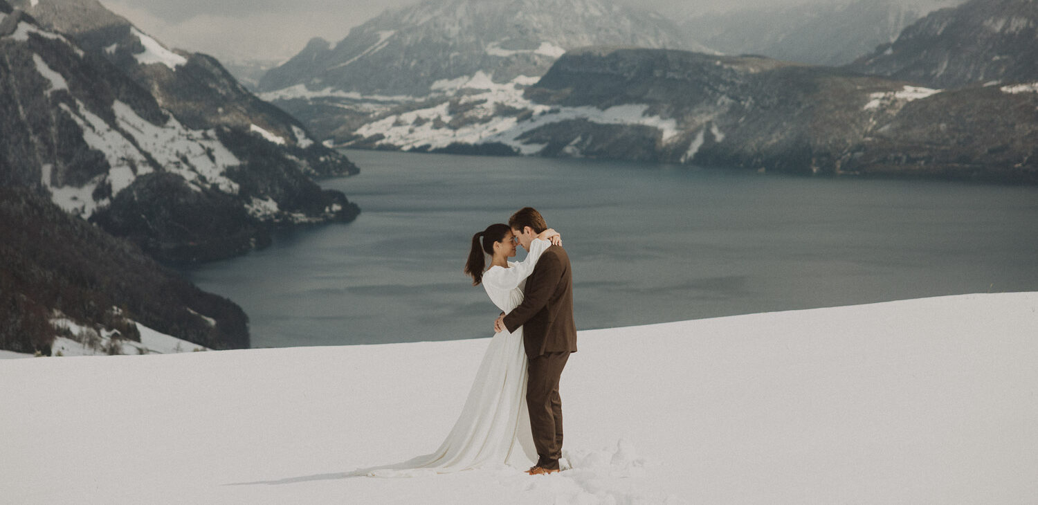 Lucerne elopement photography in a snow-covered meadow above Lake Lucerne, capturing intimate vows and a quiet mountain snow session above the lake.