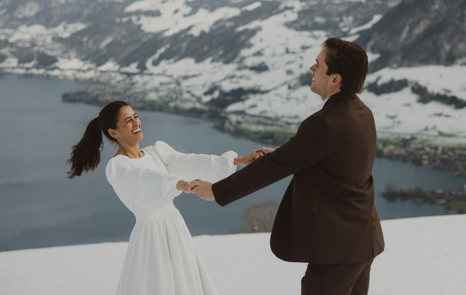 Couple during an elopement photography session in Lucerne with snow-covered alpine mountains and a lakeside backdrop.